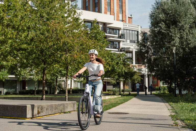 Vrouw met fietshelm op een Granville Suburban e-bike op een fietspad in de stad
